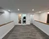 Primary bedroom / loft with Washroom featuring a wall mounted air conditioner, dark hardwood / wood-style floors, and stacked washer and clothes dryer