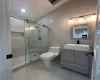 Bathroom with tile patterned flooring, vanity, toilet, and a shower with shower door