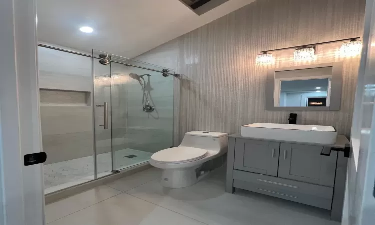 Bathroom with tile patterned flooring, vanity, toilet, and a shower with shower door