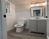 Bathroom featuring hardwood / wood-style floors, vanity, and toilet