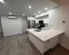 Kitchen with light stone countertops, white cabinetry, sink, stainless steel appliances, and kitchen peninsula