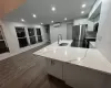 Kitchen featuring light stone countertops, appliances with stainless steel finishes, a wall unit AC, sink, and white cabinetry