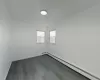 Unfurnished living room with ceiling fan, a baseboard radiator, and wood-type flooring