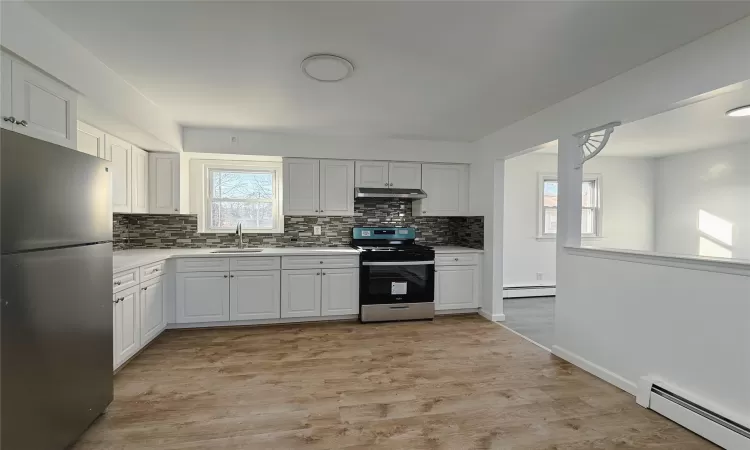 Unfurnished room featuring dark hardwood / wood-style floors and a baseboard radiator