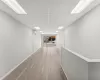 Hallway featuring light hardwood / wood-style flooring, a drop ceiling, and an AC wall unit