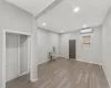 Clothes washing area with light hardwood / wood-style flooring and a wall unit AC