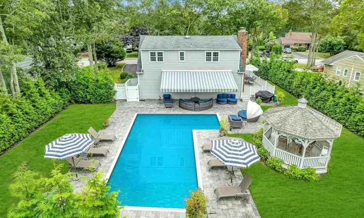 Rear view of property featuring outdoor lounge area, a patio area, a fenced in pool, and a yard