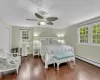 Bedroom with dark hardwood / wood-style flooring, a closet, a baseboard heating unit, and ceiling fan