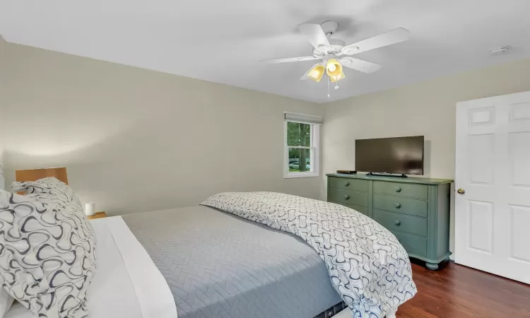 Bedroom with ceiling fan and dark wood-type flooring