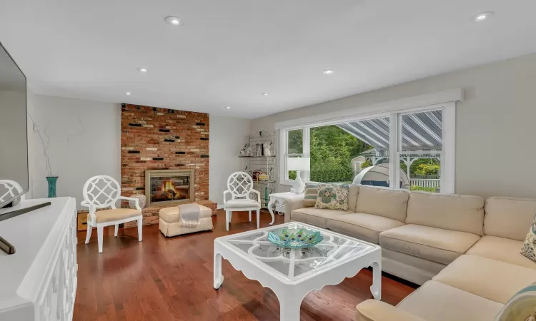 Living room featuring dark hardwood / wood-style floors and a brick fireplace