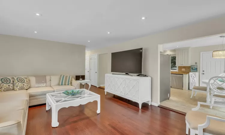 Living room with wood-type flooring and washer / dryer