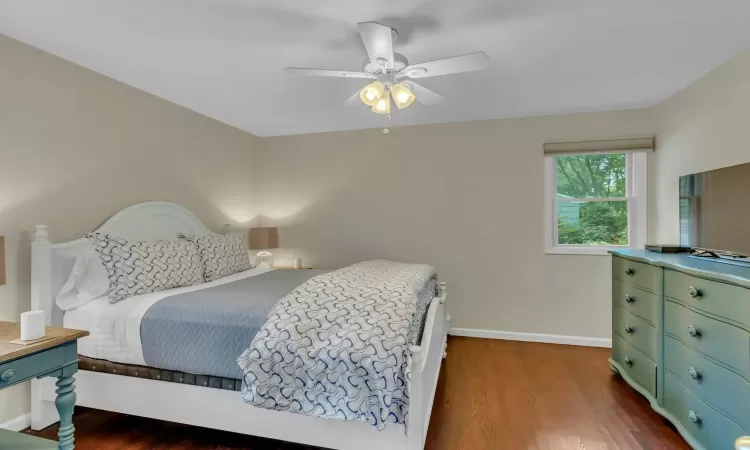 Bedroom with dark hardwood / wood-style floors and ceiling fan