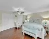 Bedroom with multiple closets, ceiling fan, and dark hardwood / wood-style floors