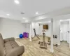 Workout area with washing machine and clothes dryer and light hardwood / wood-style flooring