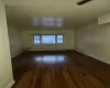 Empty room featuring dark wood-type flooring and a baseboard radiator