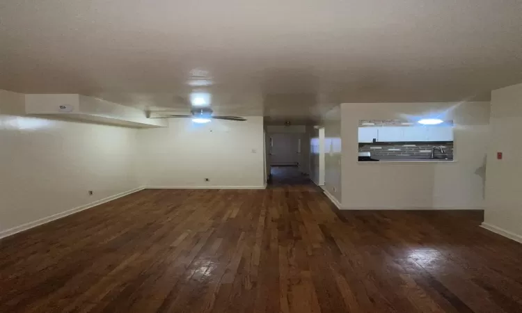 Empty room with ceiling fan, dark hardwood / wood-style flooring, and sink