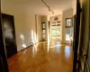 Large room with light parquet flooring and track lighting.