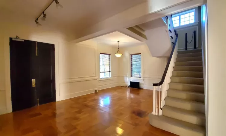 Entryway with parquet flooring, rail lighting, and plenty of natural light