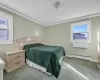 Carpeted bedroom featuring a baseboard radiator, a wall mounted air conditioner, and ornamental molding