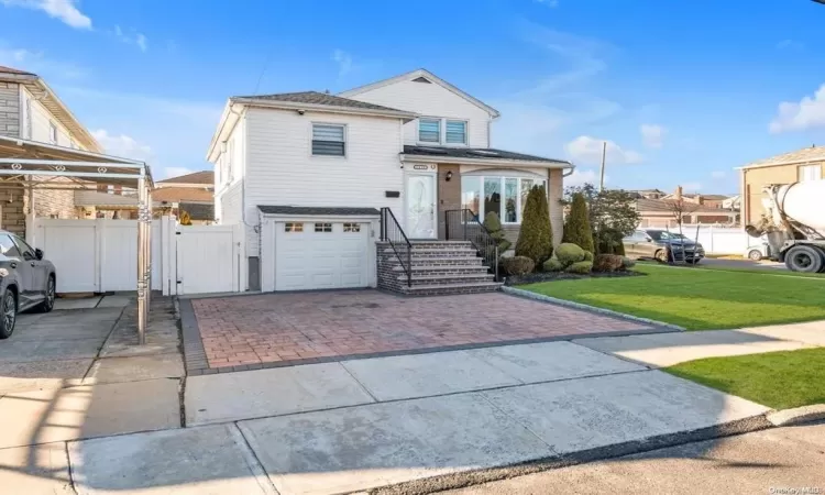 View of front property with a front yard and a garage