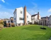 Rear view of property with a lawn, ac unit, and a deck