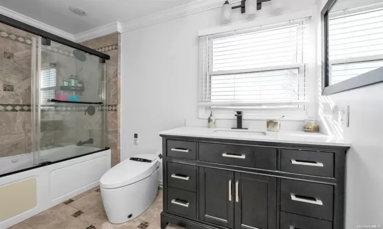 Full bathroom with vanity, combined bath / shower with glass door, tile patterned flooring, toilet, and ornamental molding