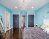 Bedroom featuring ensuite bathroom, a closet, dark hardwood / wood-style floors, and an inviting chandelier