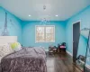 Bedroom with dark wood-type flooring and an inviting chandelier