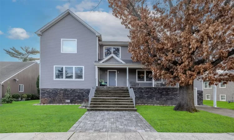 View of front of property featuring a front yard and covered porch