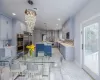 Kitchen with pendant lighting, backsplash, wall chimney range hood, built in appliances, and a kitchen island