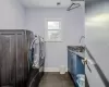 Washroom featuring dark tile patterned flooring, cabinets, sink, and washing machine and clothes dryer