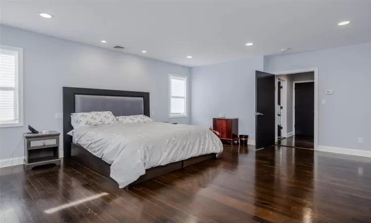 Bedroom with dark hardwood / wood-style flooring