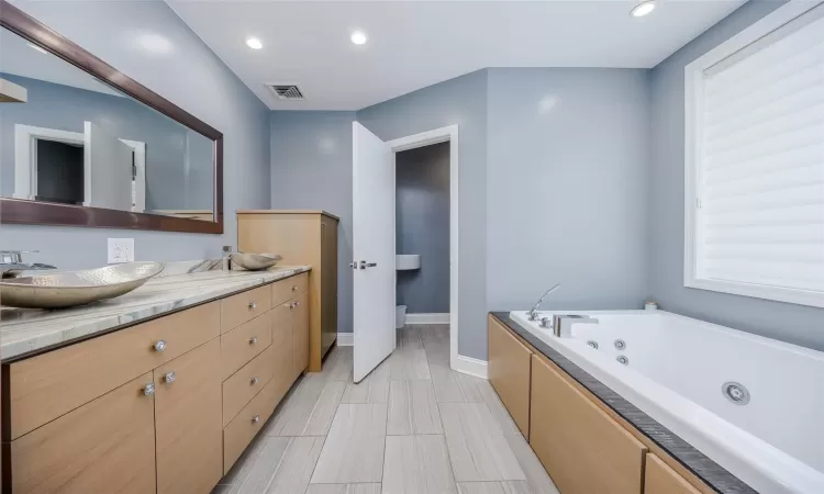 Bathroom featuring a tub to relax in and vanity