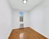 Unfurnished room featuring hardwood / wood-style floors and radiator