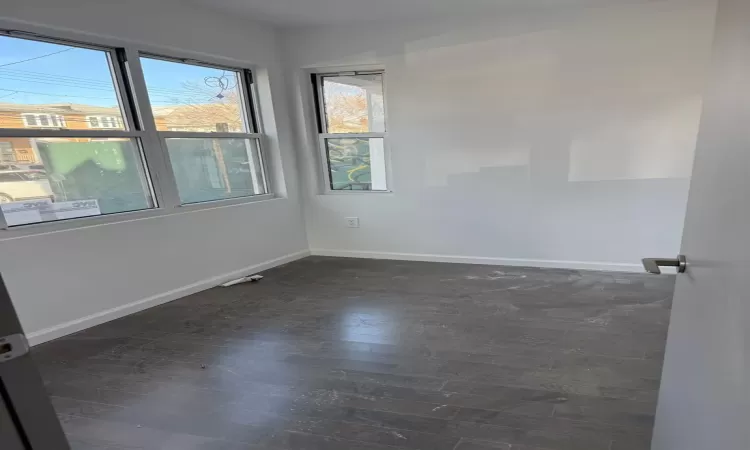 Empty room with dark hardwood / wood-style flooring