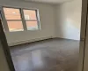 Empty room featuring baseboard heating and dark wood-type flooring