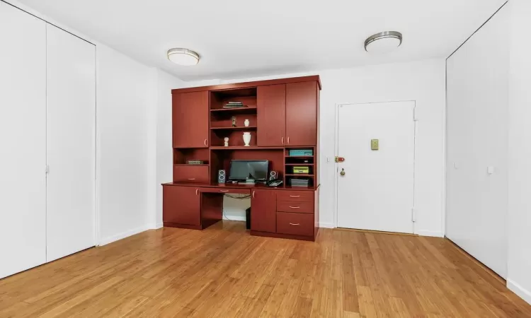 Home office featuring built in desk and light wood-type flooring