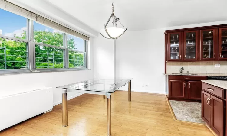 Dining room featuring sink, radiator, and light hardwood / wood-style flooring