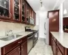 Kitchen featuring light stone countertops, sink, stainless steel appliances, backsplash, and decorative light fixtures