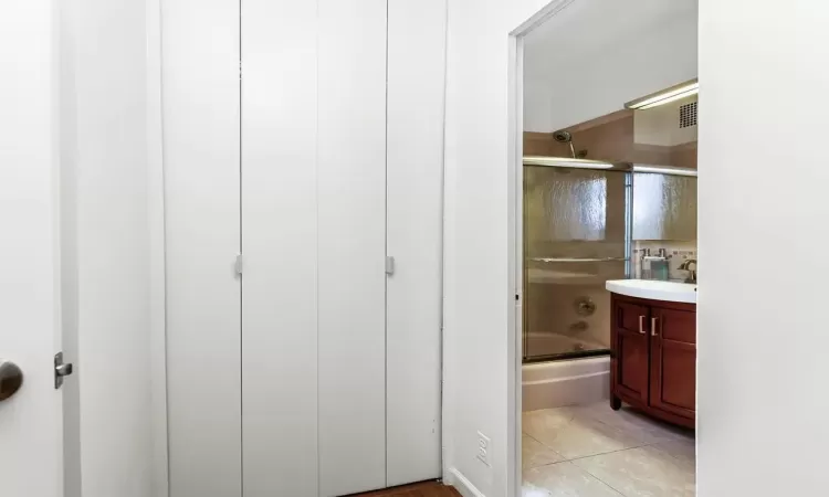 Bathroom featuring shower / bath combination with glass door, tile patterned flooring, and vanity