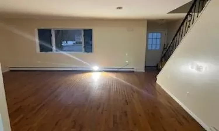 Empty room featuring dark wood-type flooring