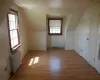 Additional living space with a healthy amount of sunlight, radiator heating unit, and light hardwood / wood-style flooring