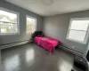 Bedroom with baseboard heating and dark wood-type flooring