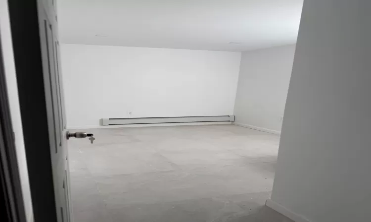 Unfurnished room featuring baseboard heating