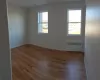 Empty room featuring light hardwood / wood-style floors, plenty of natural light, and radiator