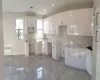 Kitchen with white cabinets, radiator heating unit, sink, and tasteful backsplash