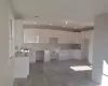 Kitchen with decorative backsplash, white cabinetry, and sink