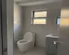 Bathroom featuring tile patterned flooring, vanity, toilet, and tile walls