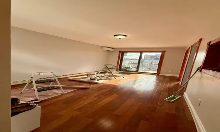 Empty room featuring a wall mounted air conditioner and dark hardwood / wood-style floors