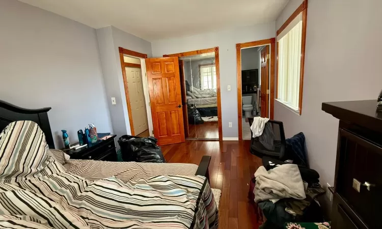 Bedroom with dark wood-type flooring and a closet